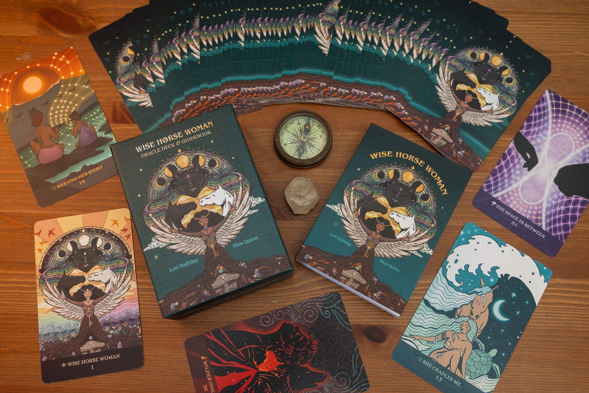 Collection of tarot cards on a wooden surface with a compass and crystal.